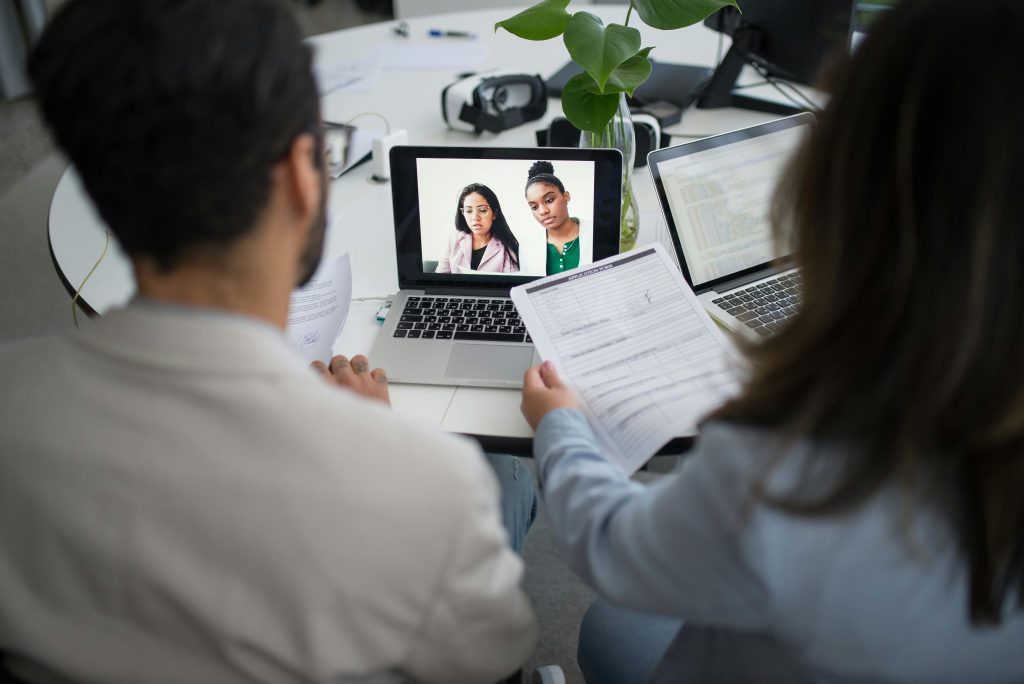 pexels-photo-8636626-8636626 Two professionals conduct a virtual job interview using laptops in a modern office.